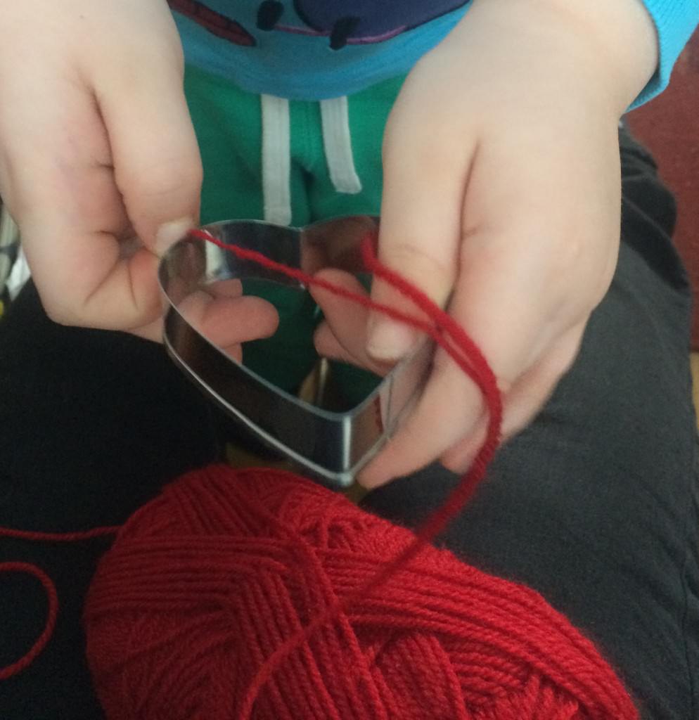 toddler playing with a ball of wool