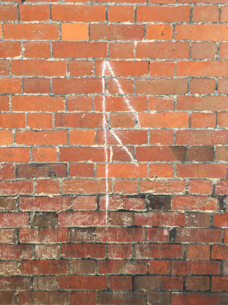 rune chalked on a wall at Avebury