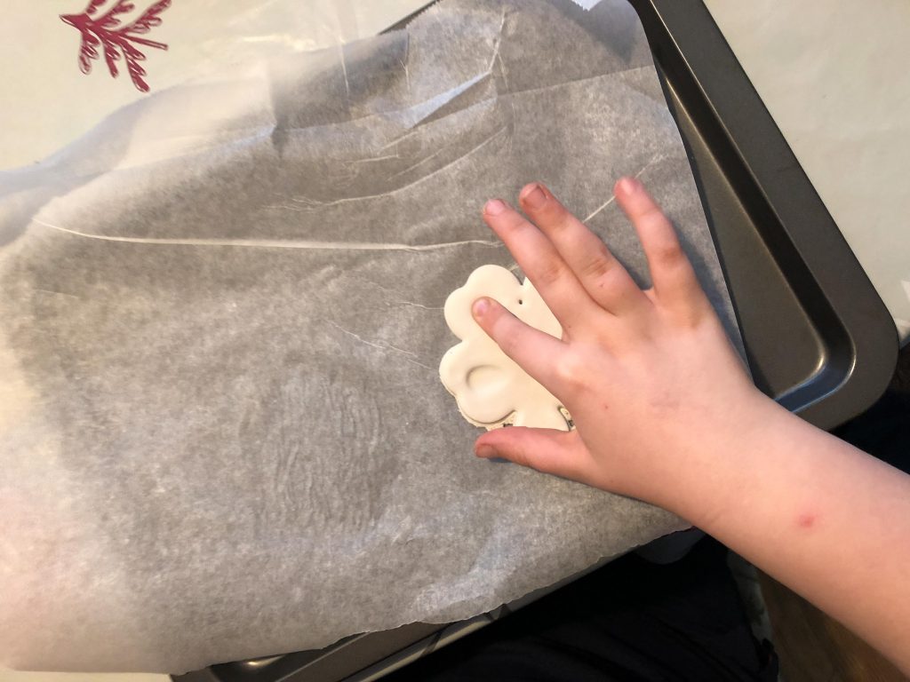 child pressing finger into clay 