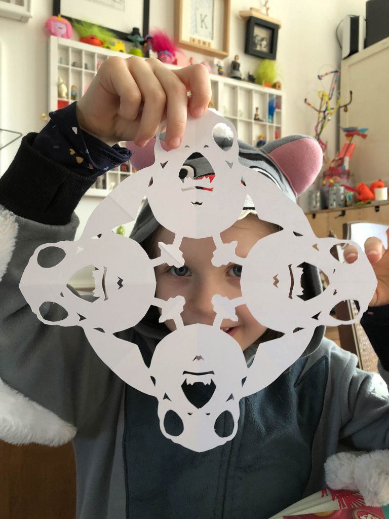 child cutting paper snowflakes