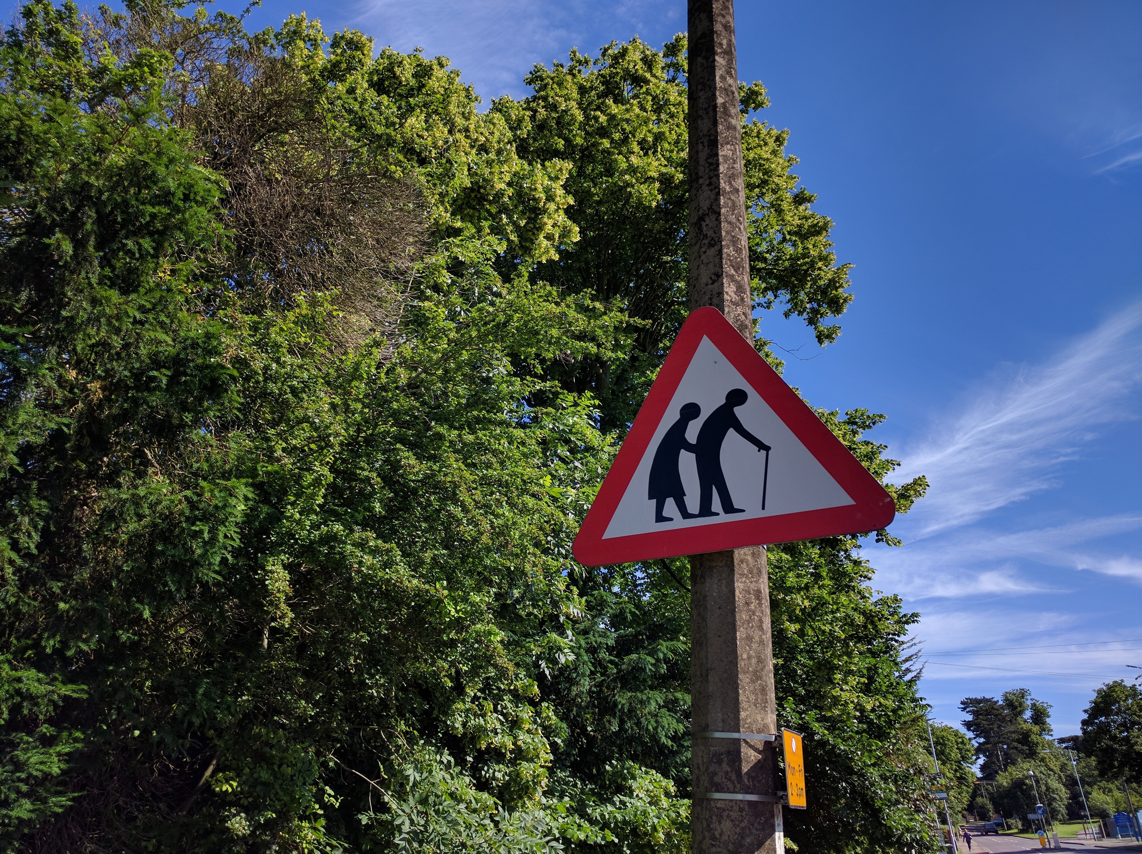 photo of a road sign featuring elderly people crossing