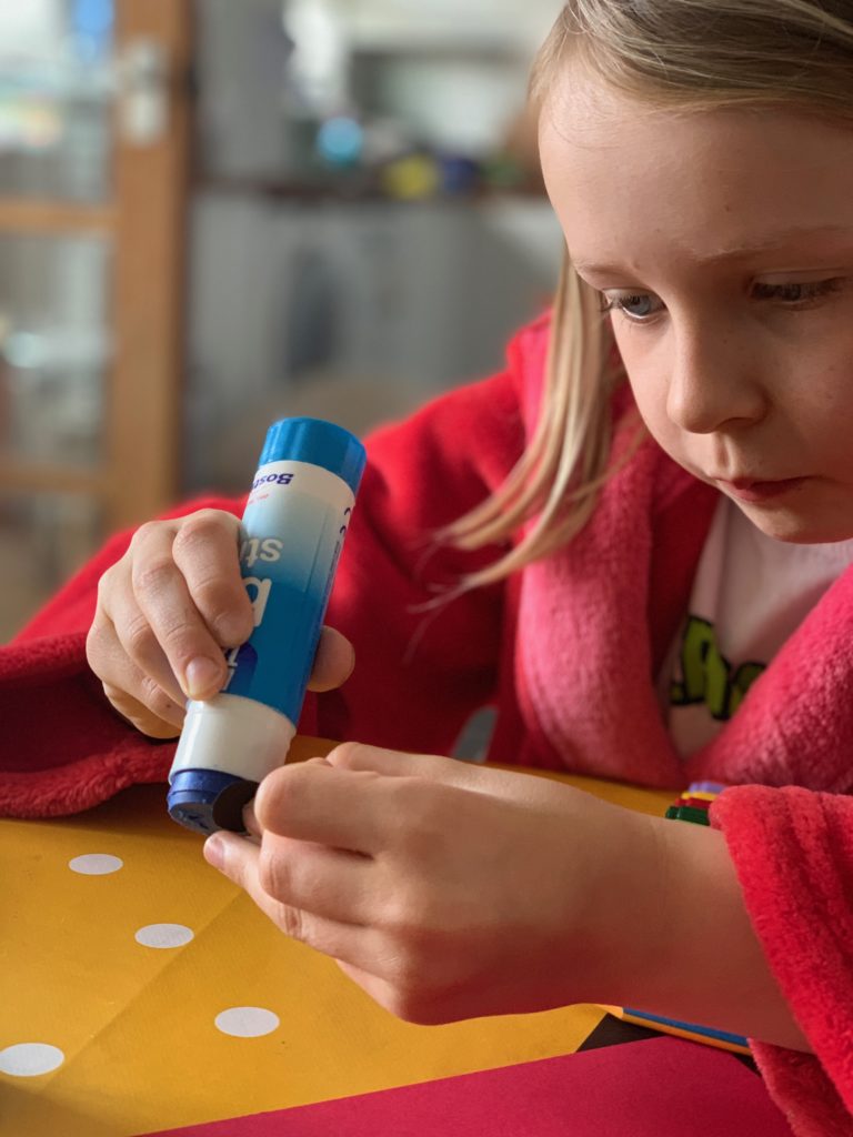 child using a glue stick