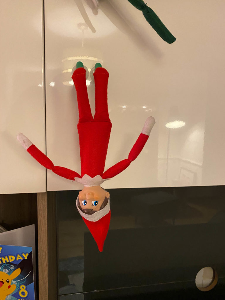 Elf on the Shelf hanging upside down