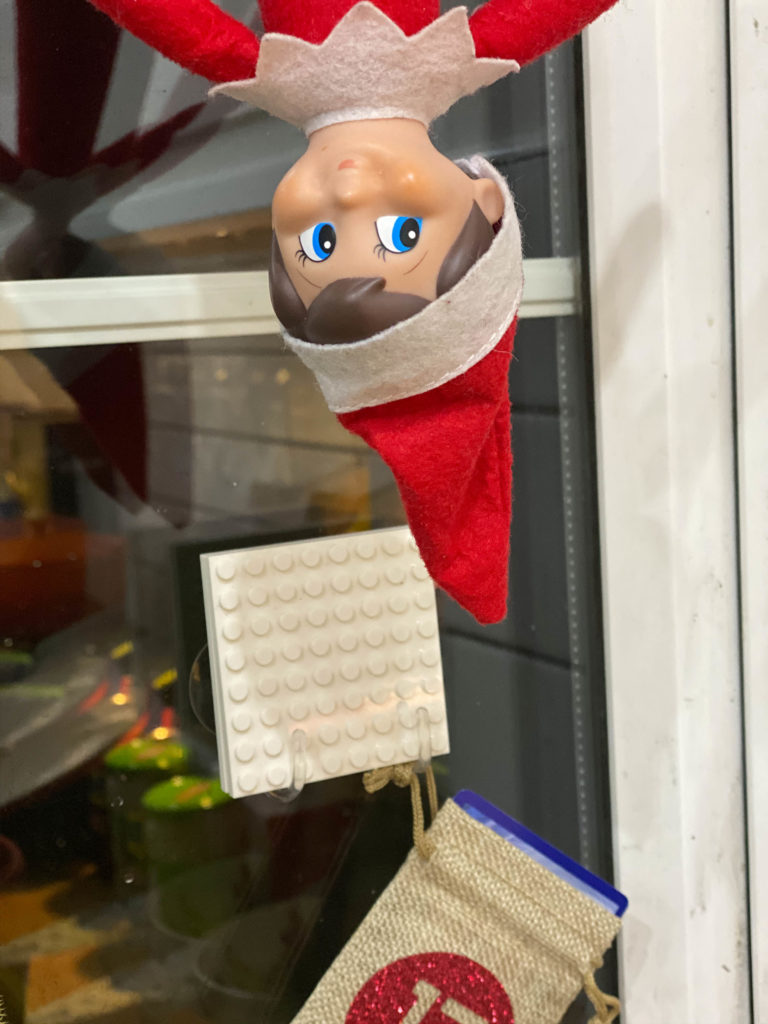 Elf on the Shelf hanging upside down