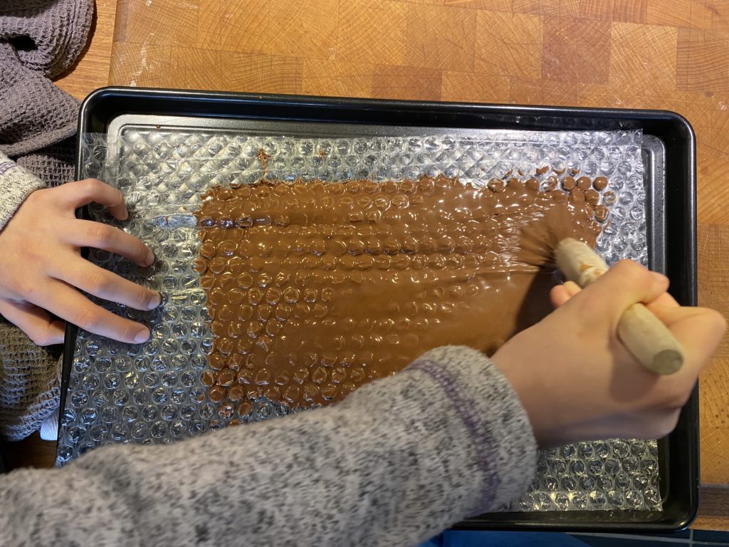 brushing chocolate over bubble wrap